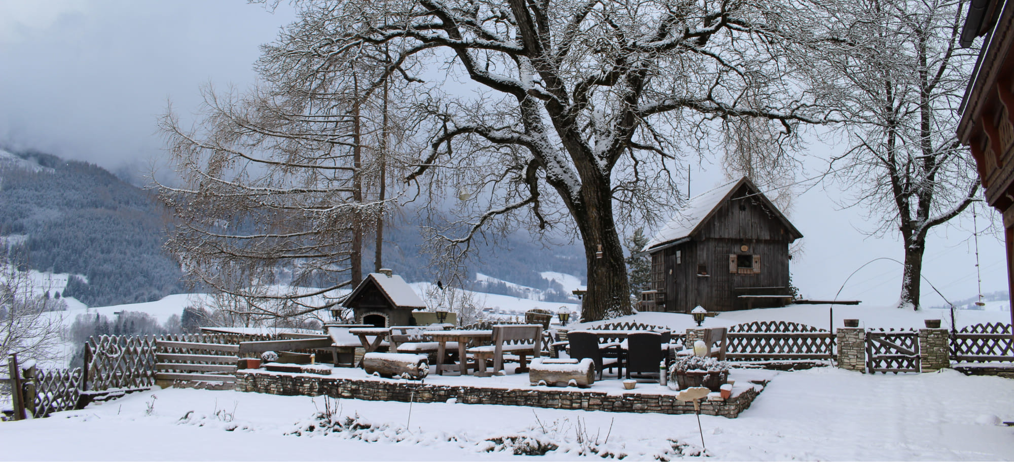 Verschneite Gartenlandschaft im Winter am Bauernhof Lutzmannhof in Irdning, Steiermark